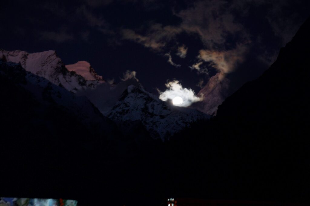 swargarohini peak with the moon over it